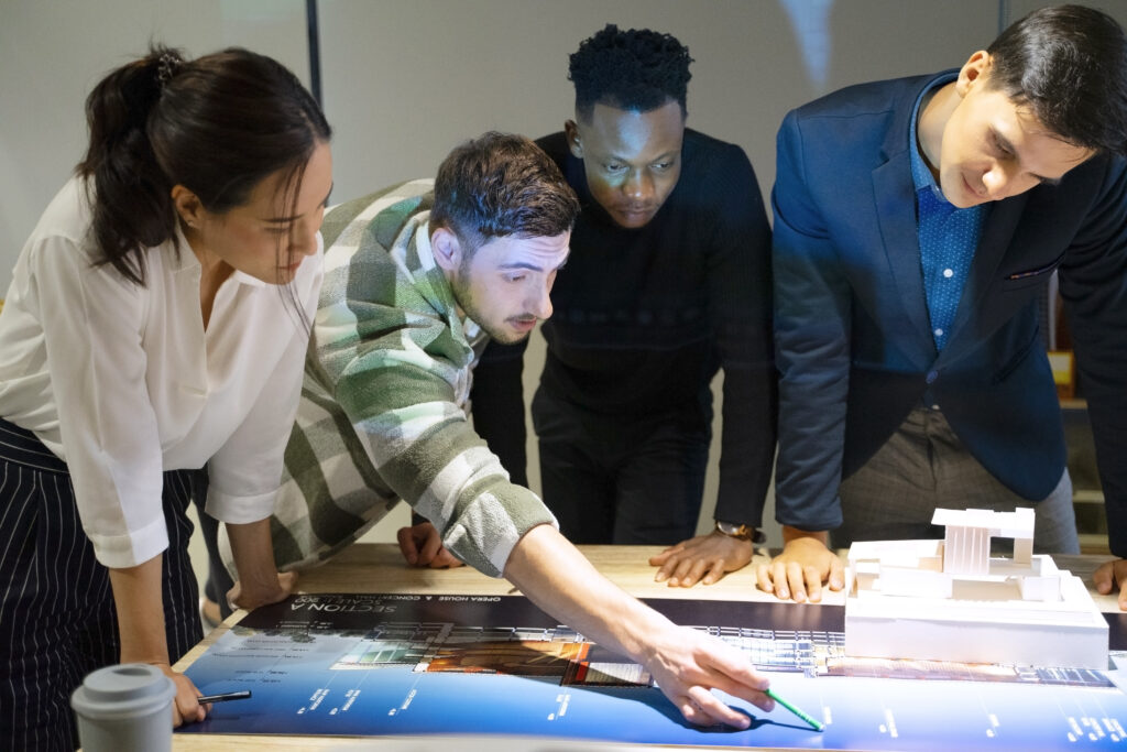 Employees working together over a table in an office.