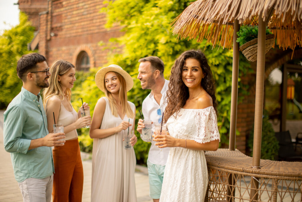 Group of happy young people having fun outdoors with drinks