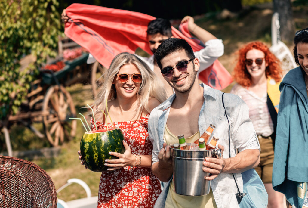 Group of young people having fun and enjoying a summer party with drinks.