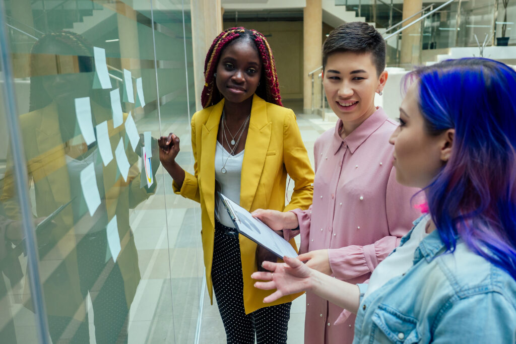 Diverse group looking at board with notes