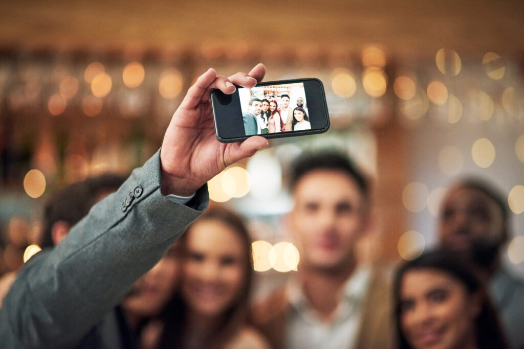 Man taking a selfie of a professional group of people.