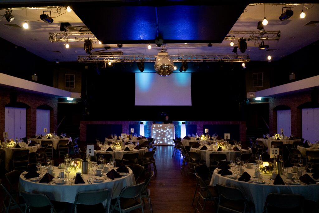 Venue 1 at ISH Venues is set up in banquet style with mood lighting.