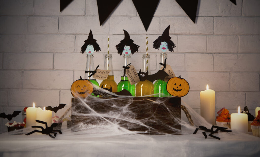 DIY witches made with green bottles inside box with spider webs