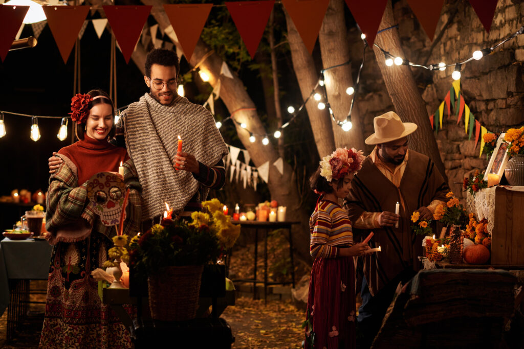 People celebrating traditional mexican holiday together outdoors, they standing at altar and remembering their dead relatives