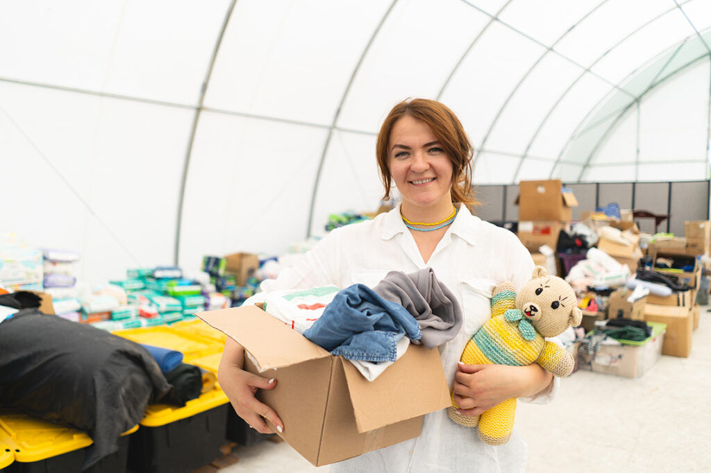 Volunteer woman preparing donation boxes for people. 