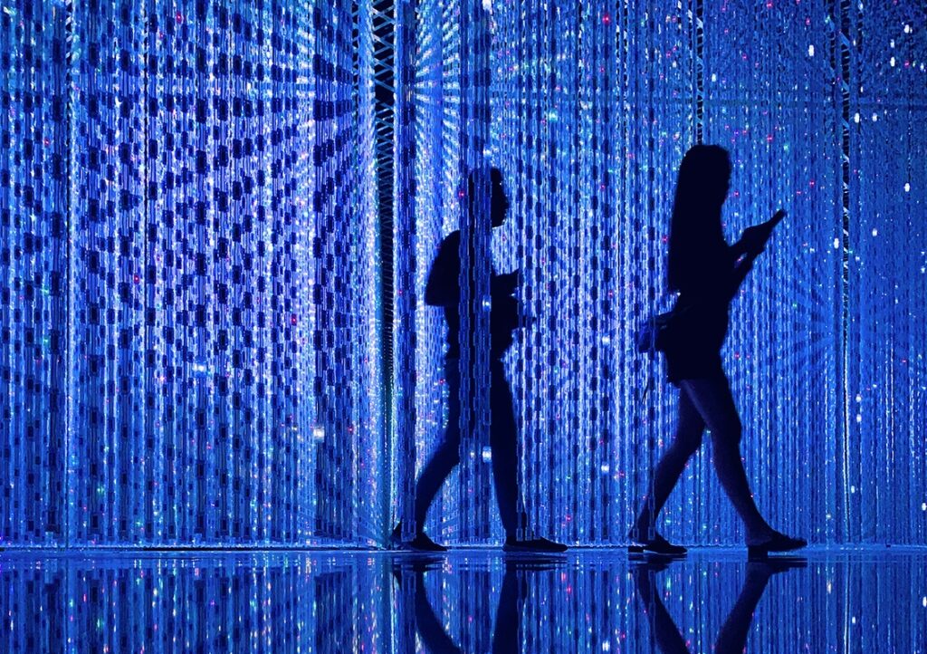 people walking through a light exhibit, an immersive experience at ArtScience Museum