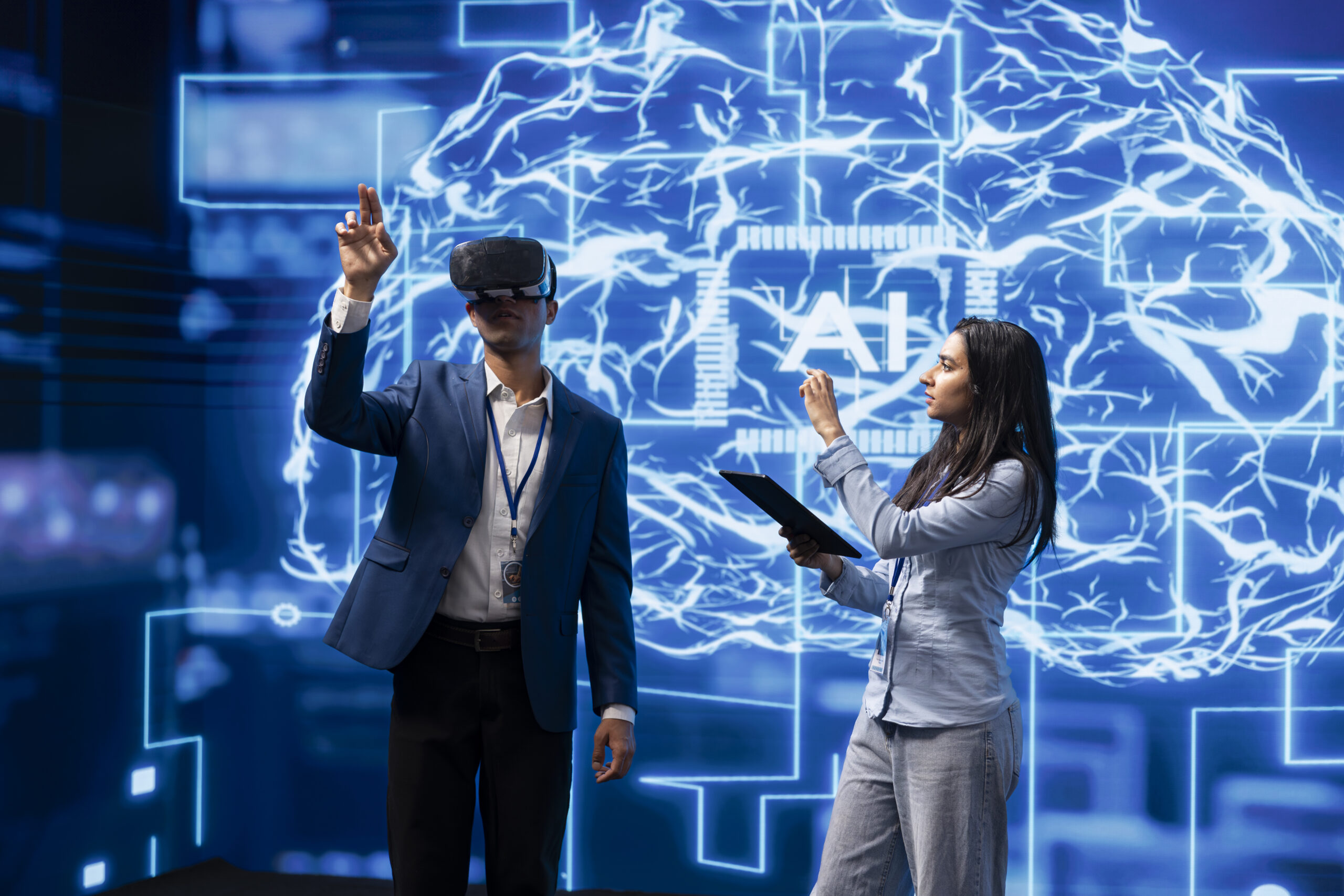 IT team member wearing VR headset looking at hologram next to coworker